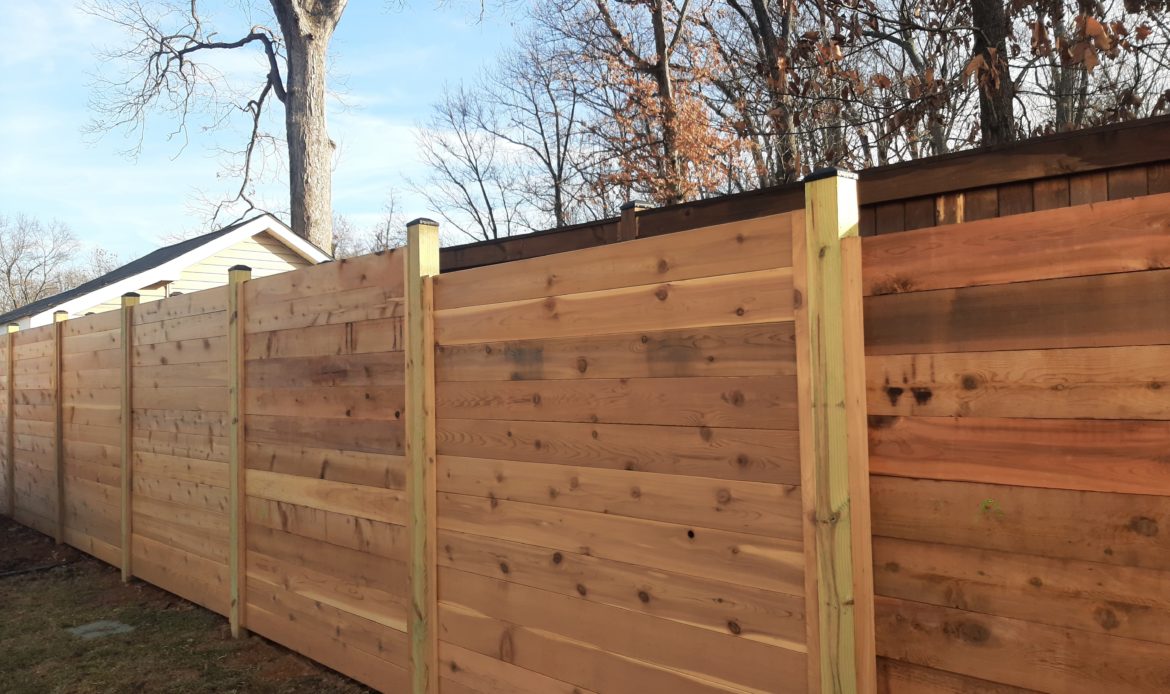 6 foot Horizontal cedar stepped fencing with no spacing between the pickets with standard black post caps