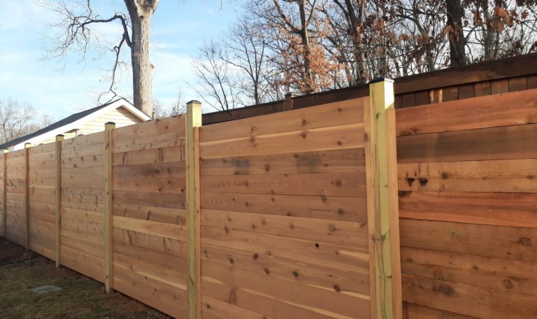 6 foot Horizontal cedar stepped fencing with no spacing between the pickets with standard black post caps