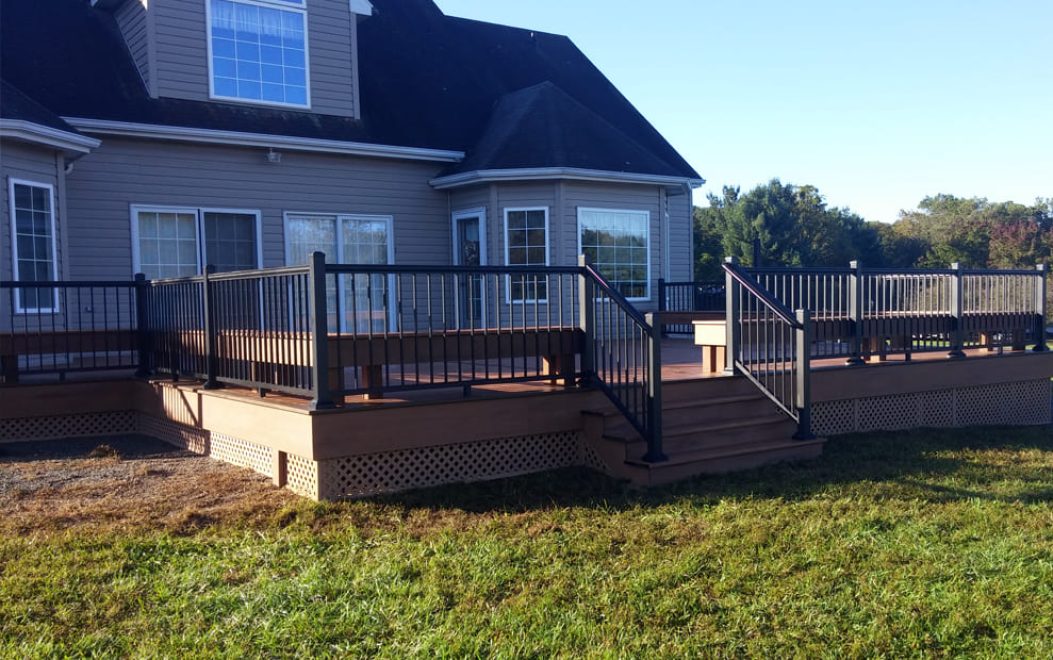 Composite deck with black aluminum railing, brown composite fascia and brown lattice