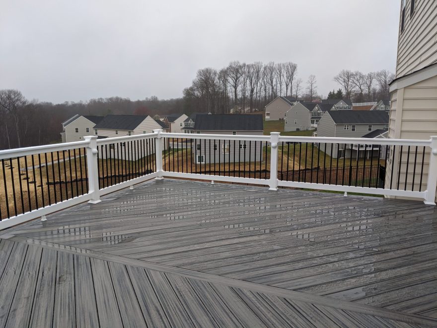 Trex Transcend Island Mist deck boards in a Herringbone layout with White Washington Vinyl Railing and Black Round Aluminum Balusters in Eldersburg, MD