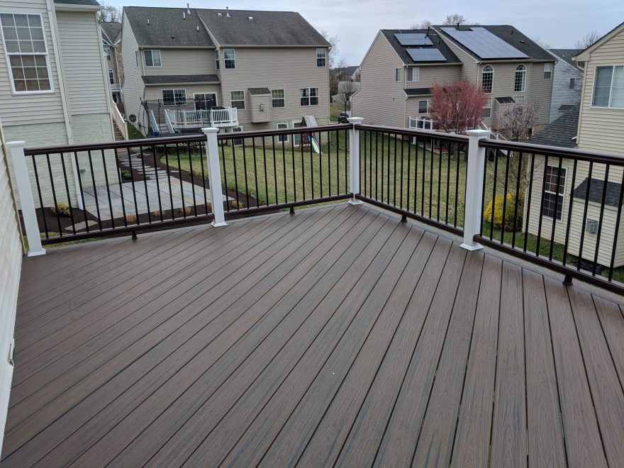 Trex Transcend Spiced Rum Decking installed in diagonal pattern with Trex Vintage Lantern Top and Bottom Handrail with Black Round Aluminum Balusters and White Vinyl Posts