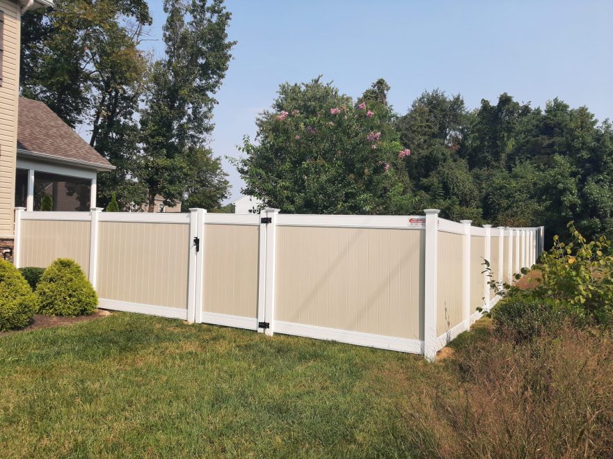 Two toned tan and white vinyl privacy fence with single walk gate