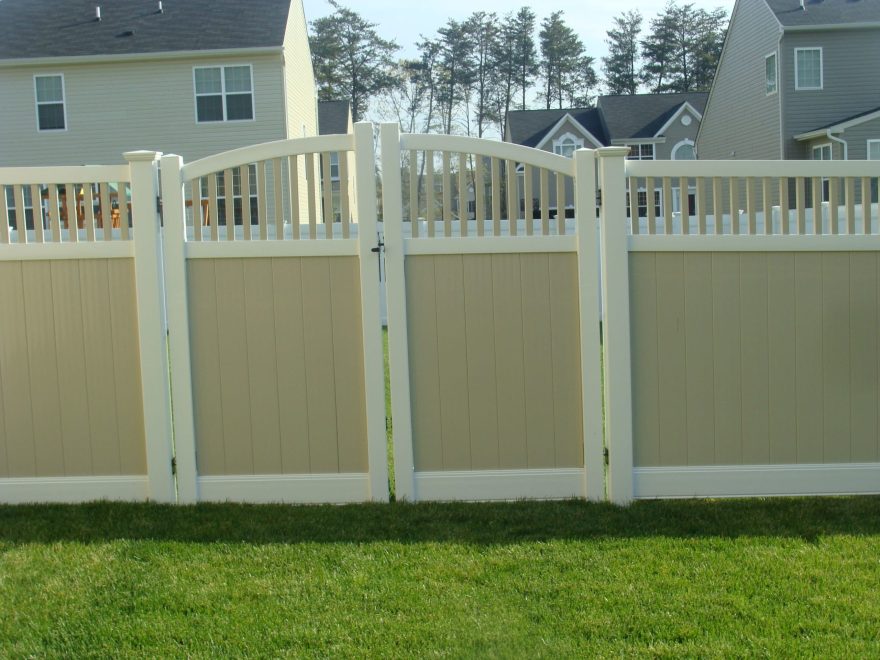 Two toned tan and white vinyl privacy fence with tan closed spindle infill topper